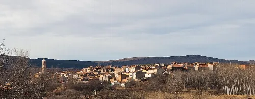Panoramischer Blick auf San Martín del Río mit Häusern und Hügeln im Hintergrund.