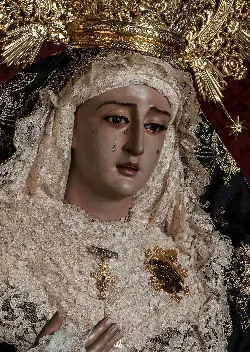 Statue of Virgen de la Soledad with tears and ornate clothing.
