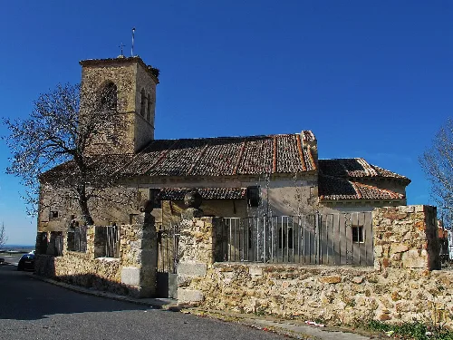 Old church with tower and stone wall in Torrecaballeros.
