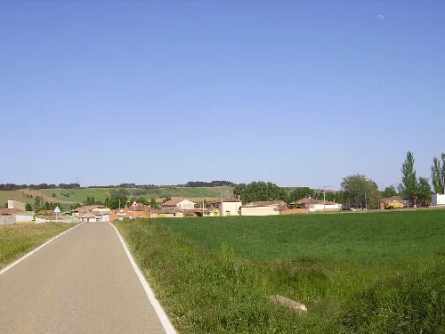 Rural road with houses and green fields in Quintanilla de Onsoña.