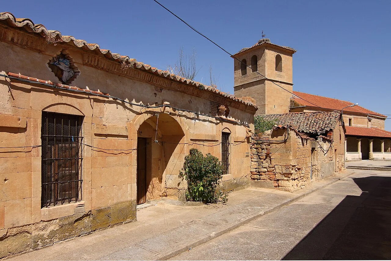 Street with stone houses and a church tower in San Morales.