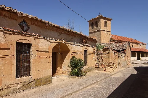 Street with stone houses and a church tower in San Morales.