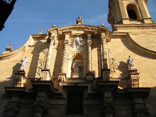 Fassade einer Kirche mit Skulpturen und Steinsäulen.