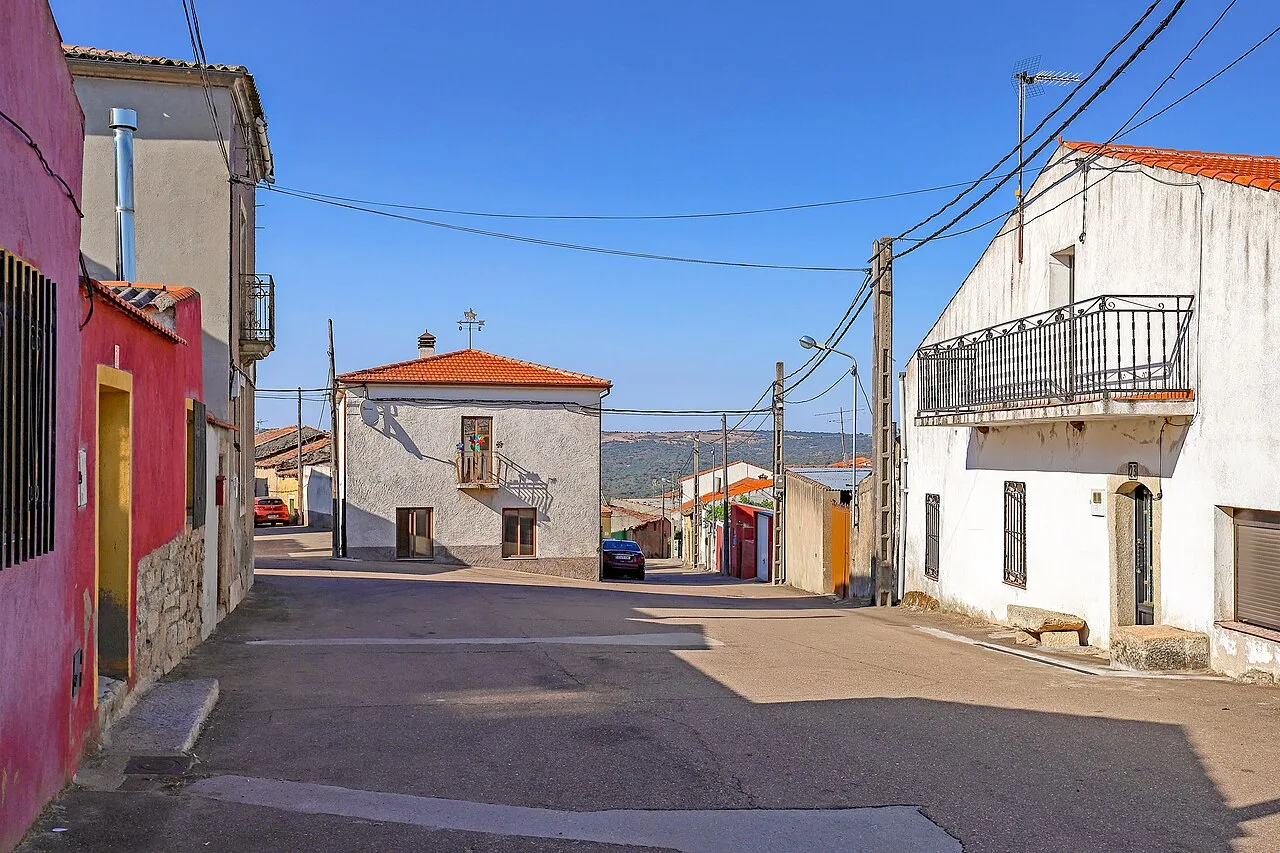 Calle en Puerto Seguro con casas blancas y cielo azul.