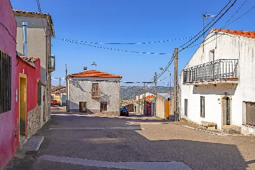 Calle en Puerto Seguro con casas blancas y cielo azul.