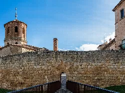 Stone walls in Almazán with church and historic buildings.