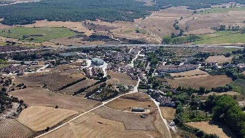 Aerial view of a village surrounded by fields and roads in Burgos.