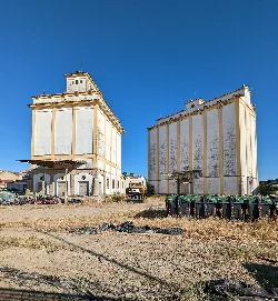 Zwei alte Getreidesilos in Miajadas vor klarem blauen Himmel.