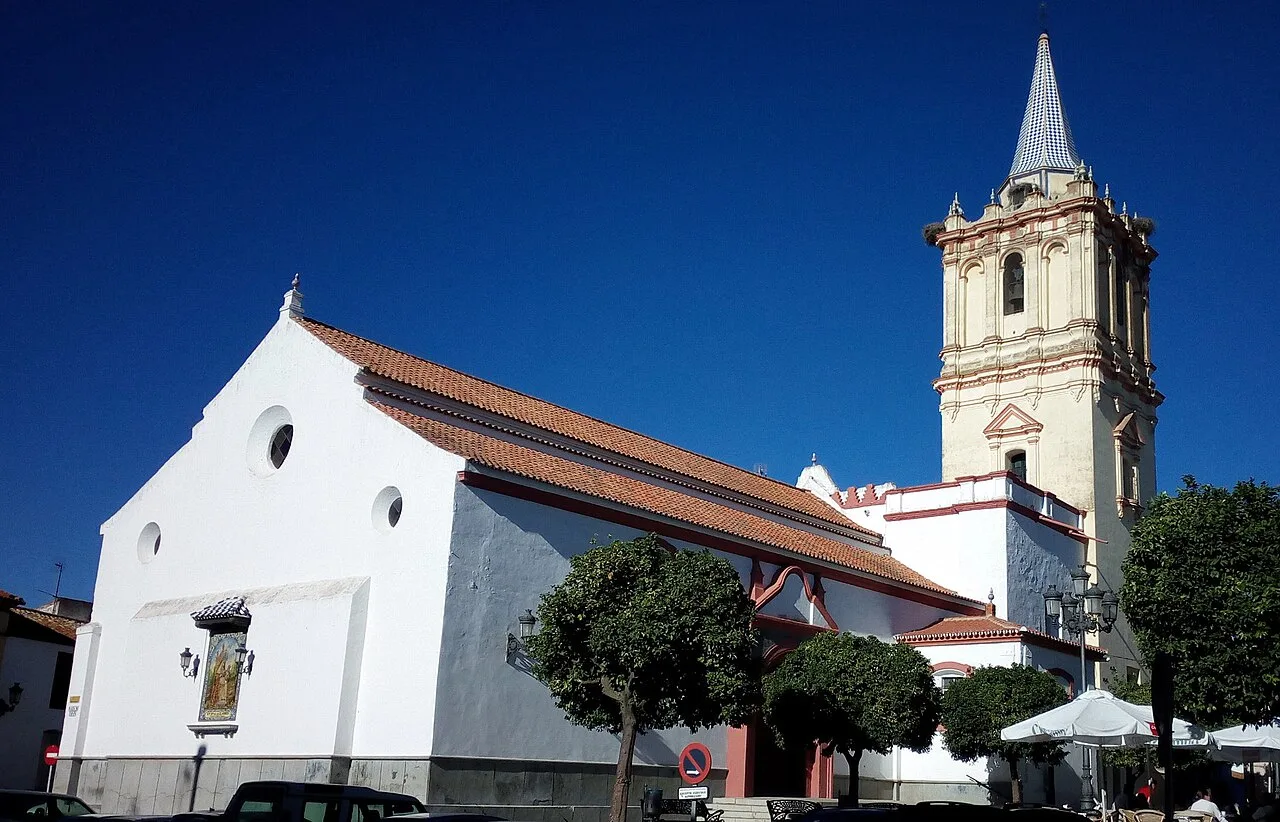 Pfarrkirche St. San Bartolomé Apóstol in Beas, mit Turm und weißer Fassade.