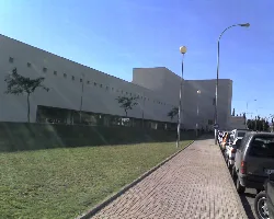Modernes Fakultätsgebäude mit Bäumen und Autos auf dem Bürgersteig