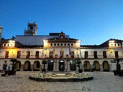 Nules town hall with illuminated facade and fountain in the square.
