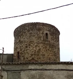 Runder Steinturm mit kleinen Fenstern und Ziegeldach in Jaraicejo.