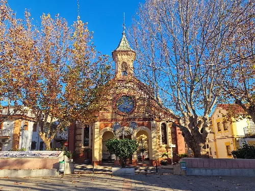 Kirche mit Turm und Bäumen in Güevéjar, Granada.