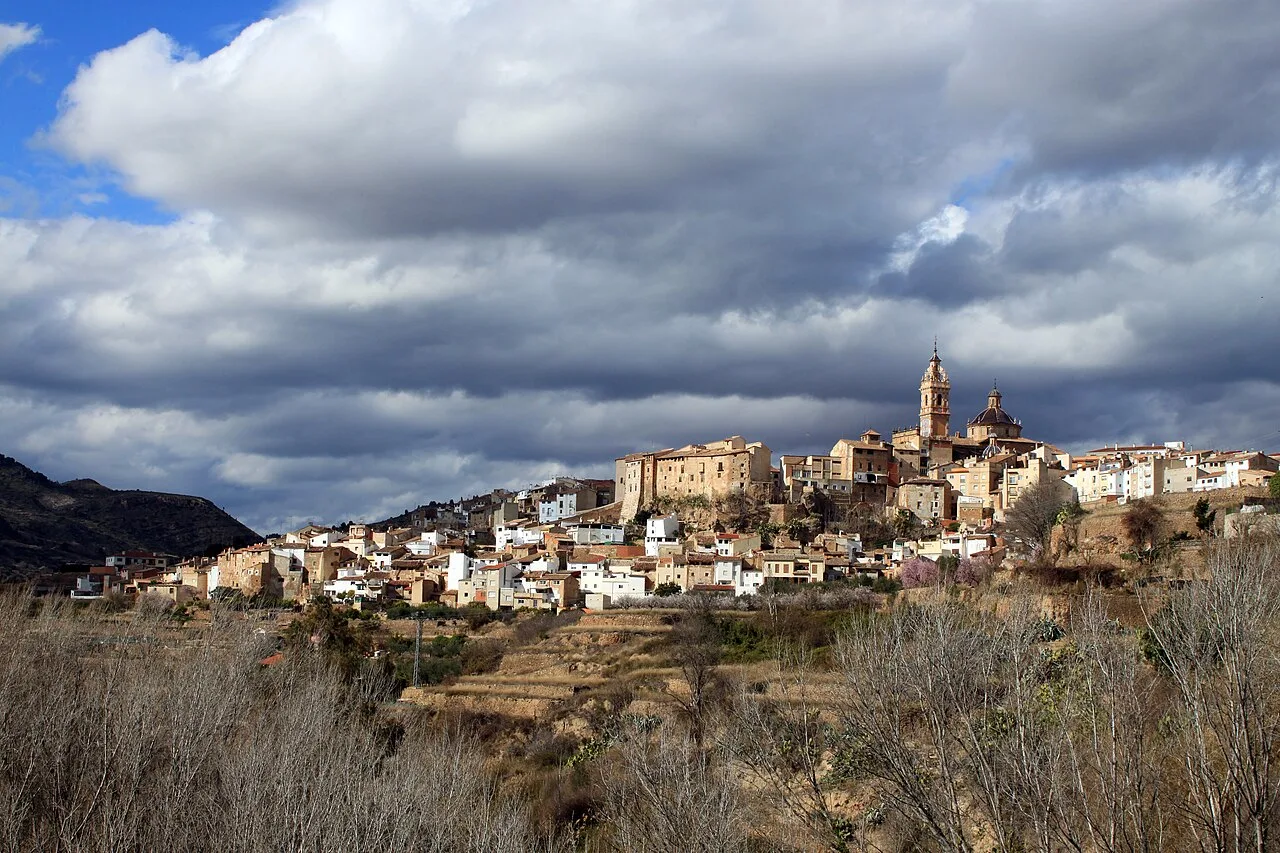 Vista panorámica de Chelva con edificios y una iglesia en lo alto.