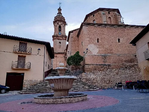 Plaza de España in Aguaviva mit Brunnen und Kirchturm.
