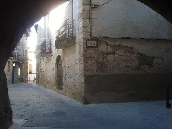 Calle estrecha con edificios antiguos y balcones en Cretas.