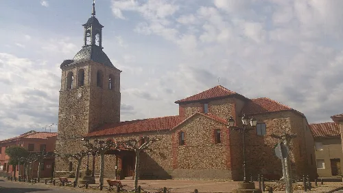 Steinige Kirche mit Turm und Glockenturm in Llamas de la Ribera.