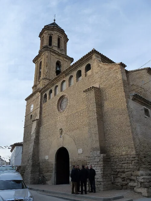 Facade of an old church with tower and entrance arch in Bujaraloz.