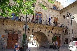 Town hall arch with flags and pedestrians.
