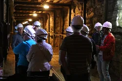 Group of people with helmets inside a mine.