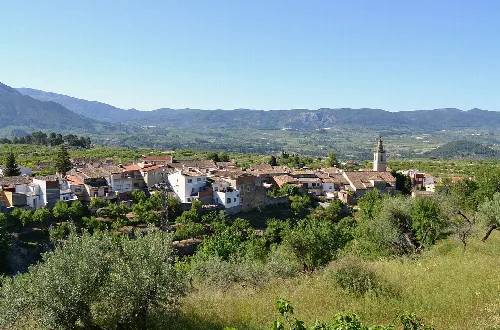 Panoramablick auf Millena mit Häusern und Bergen im Hintergrund.