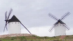 Two windmills on a cloudy landscape.