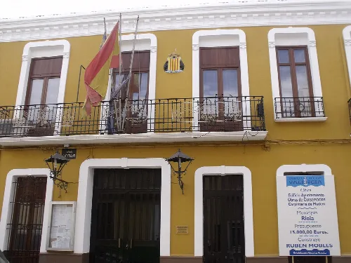 Fassade des Rathauses von Riola mit Flaggen und Wappen.