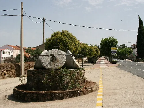 Perales del Puerto: maalstenen uit voormalige oliemolen als monument langs de weg EX-109