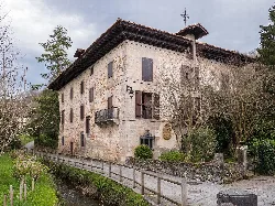 Stone building with balconies and a tiled roof in Vera de Bidasoa, Navarra.