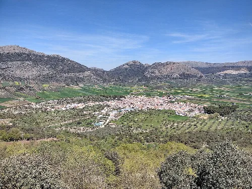 Blick auf Alfarnate, Dorf in Málaga, umgeben von Bergen und Feldern