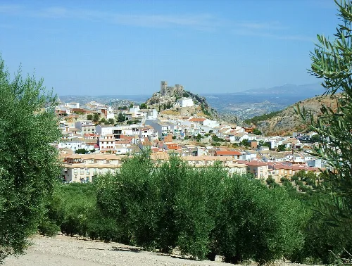 Blick auf Luque mit Burg auf Hügel und weißen Häusern.