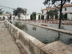 Stone wall watering place with water in Guadalcázar.