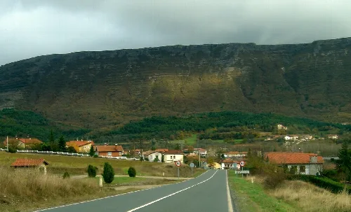 Ländliche Straße mit Häusern und Hügeln in Zuhatzu Kuartango, Álava.