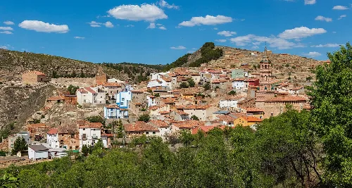 General view of the village of Monterde, province of Zaragoza, Aragon, Spain. The most important heritage of Monterde, that has a population of 198 (data from 2016), are the church of the Assumption (on the right) of mudéjar-style and erected in the 15th century and its medieval castle (top left) from the 14th century.