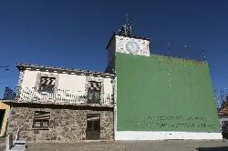 Town hall building of Morasverdes with clock and mural on the facade.