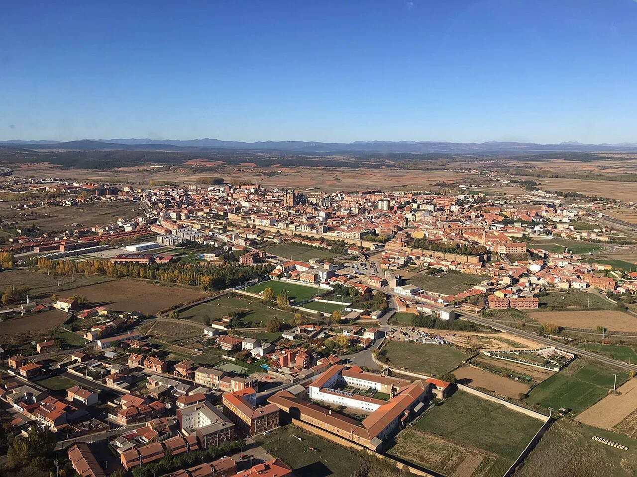 Vista aérea de Astorga con edificios y campos rurales.