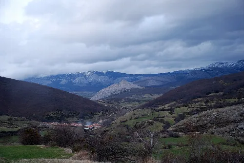 Vista de montañas con nieve y cielo nublado en La Pernía.