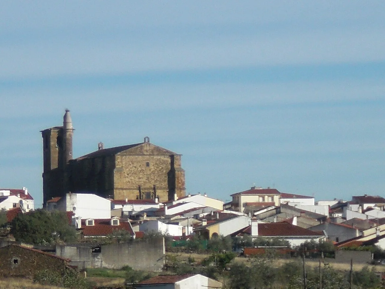 View of the center of Malpartida de Plasencia with church and white houses.