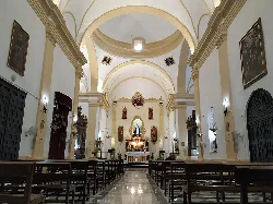 View of the church interior with altar and high vaulted ceilings.