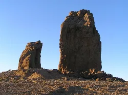 Rock formations in a dry landscape with a clear blue sky.