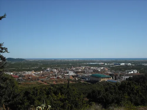 Landschaft mit einer Stadt und offenen Feldern am Horizont.
