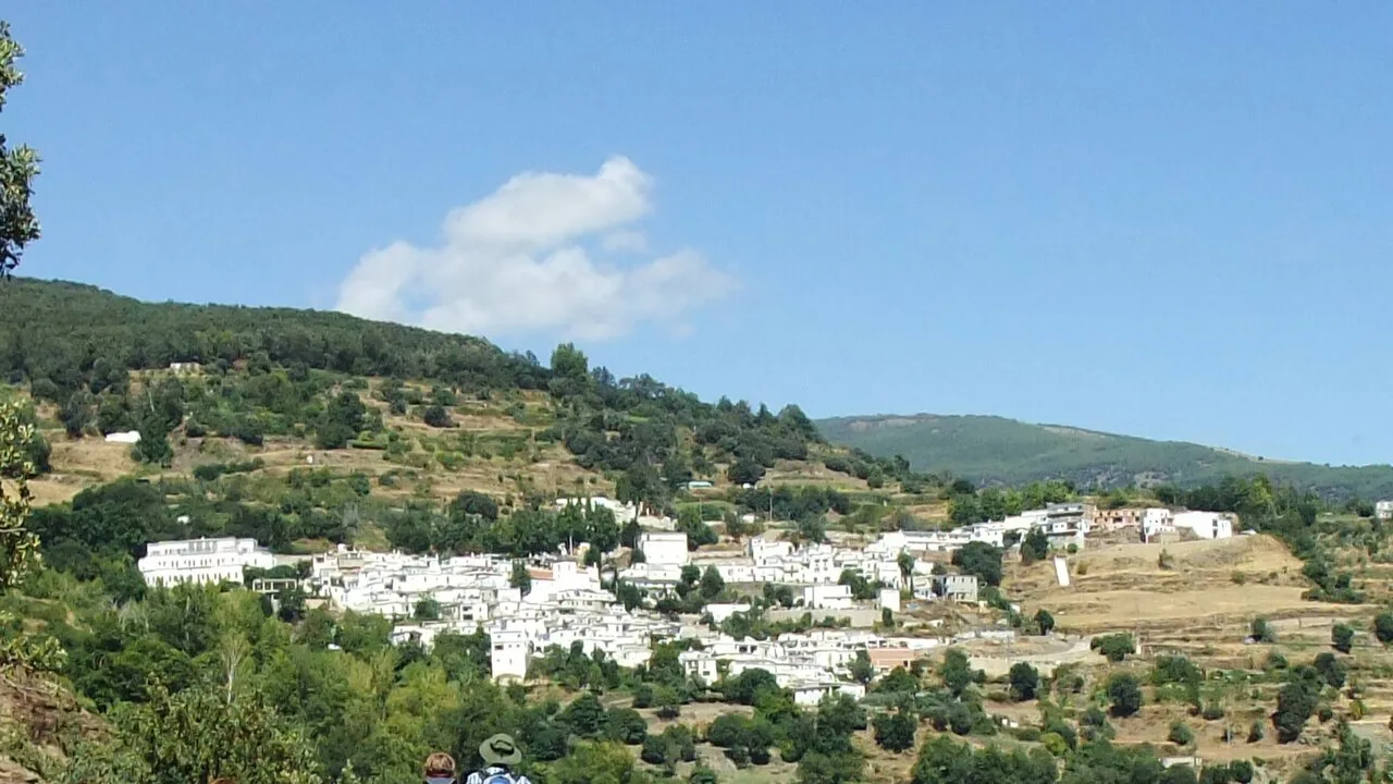 Blick auf Busquístar in Granada mit weißen Häusern und Bergen im Hintergrund.