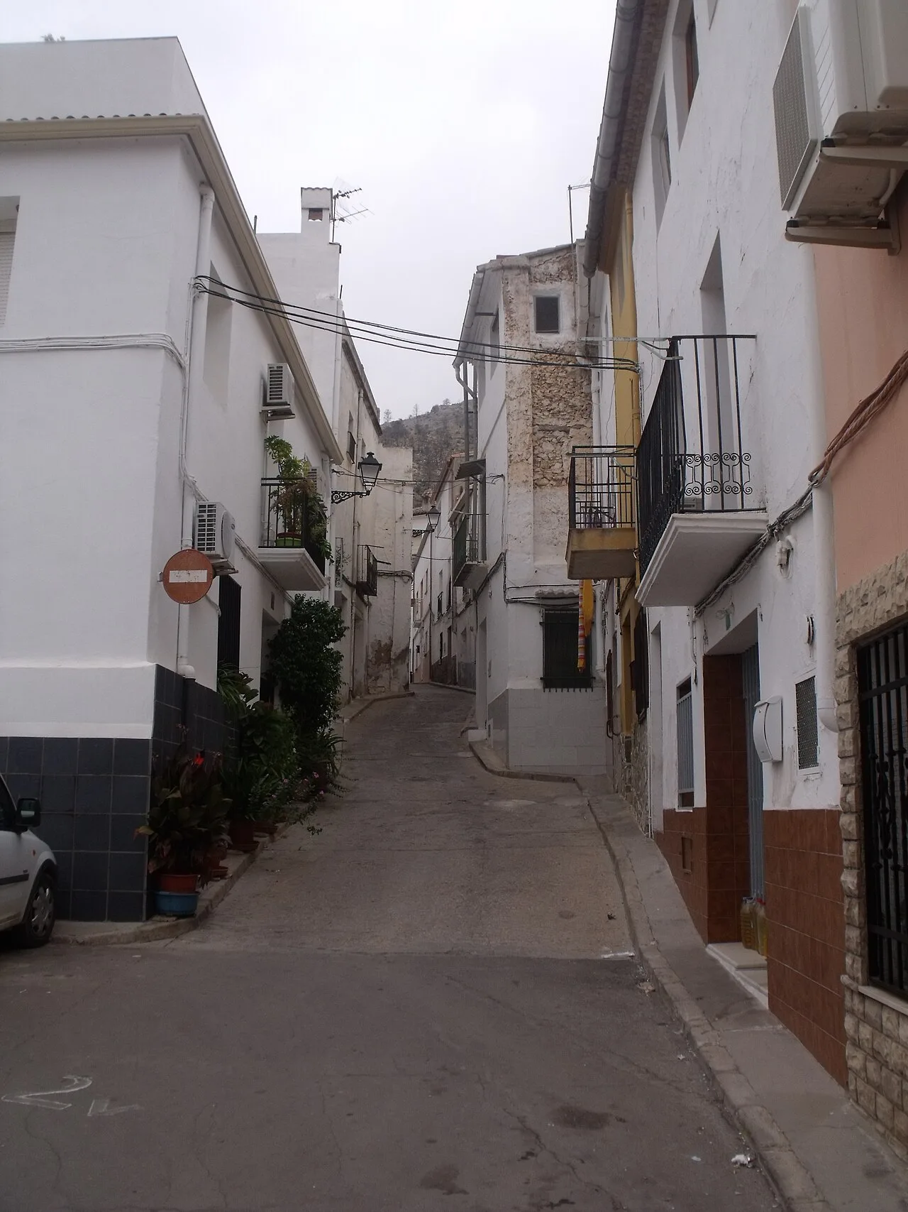 Calle estrecha con casas blancas y balcones en Gestalgar, Valencia.
