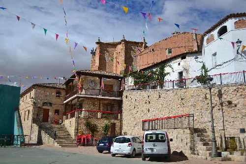 View of the square with buildings and cars in Argecilla.
