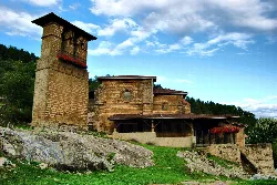 Santuario de Santa María del Yermo en Llodio con torre y fachada de piedra.