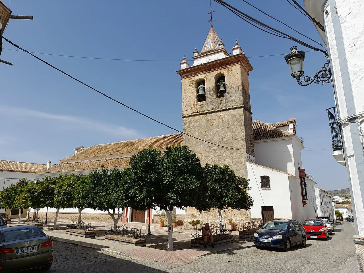 Kirche mit Turm und Bäumen auf dem Platz von La Puebla de los Infantes.
