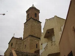 Glockenturm der Kirche La Purísima in Turre, umgeben von modernen Gebäuden.