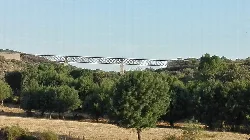 Eisenbrücke über ein Tal mit Bäumen in Villavieja de Yeltes.