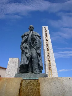 Statue von León Felipe mit Denkmal und blauem Himmel.