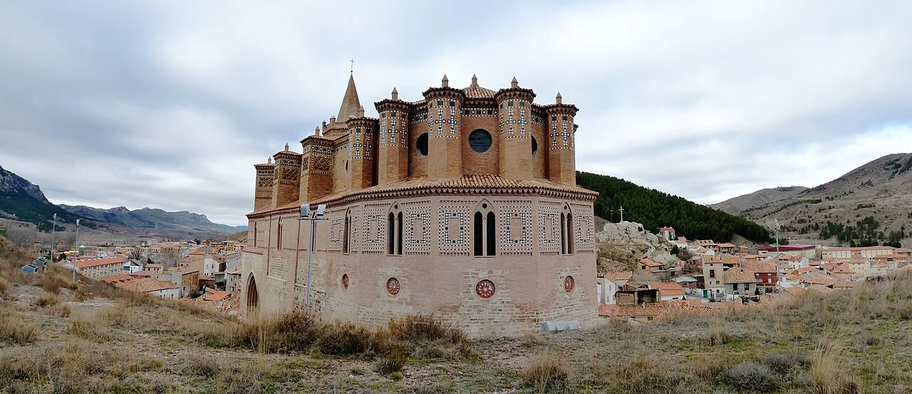 View from the apse of a medieval church in Montalbán, with towers and mountain landscape.